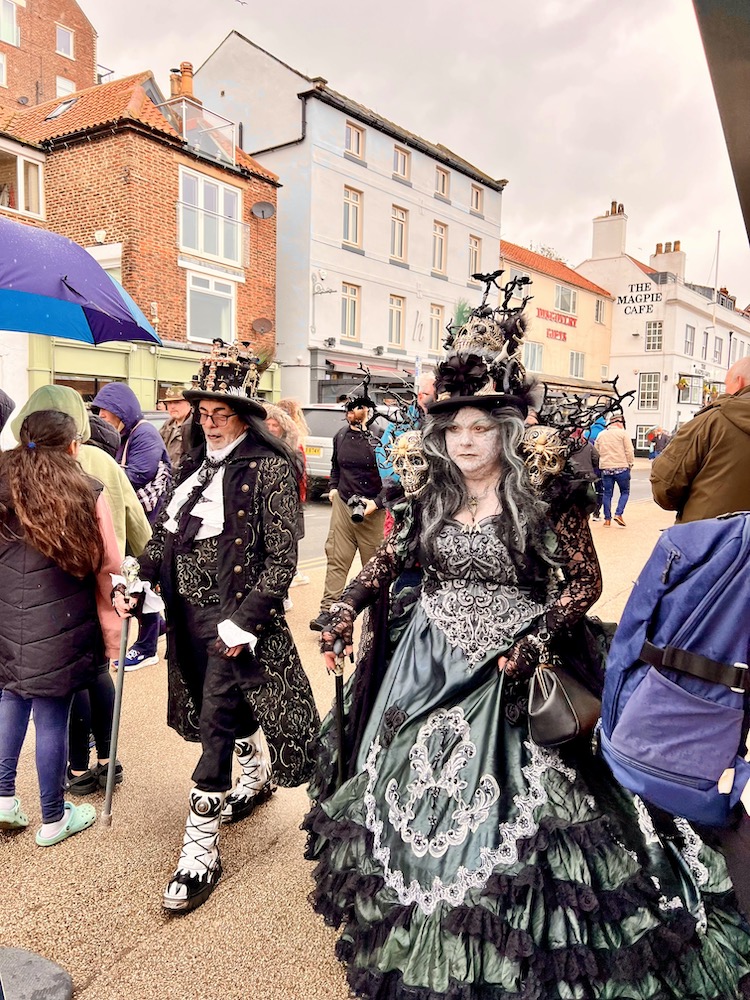 man and woman walking through Whitby town on Goth weekend