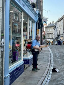 one man band playing music on UK cobbled street