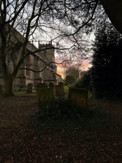 a photo of a church by sunset in a village in England